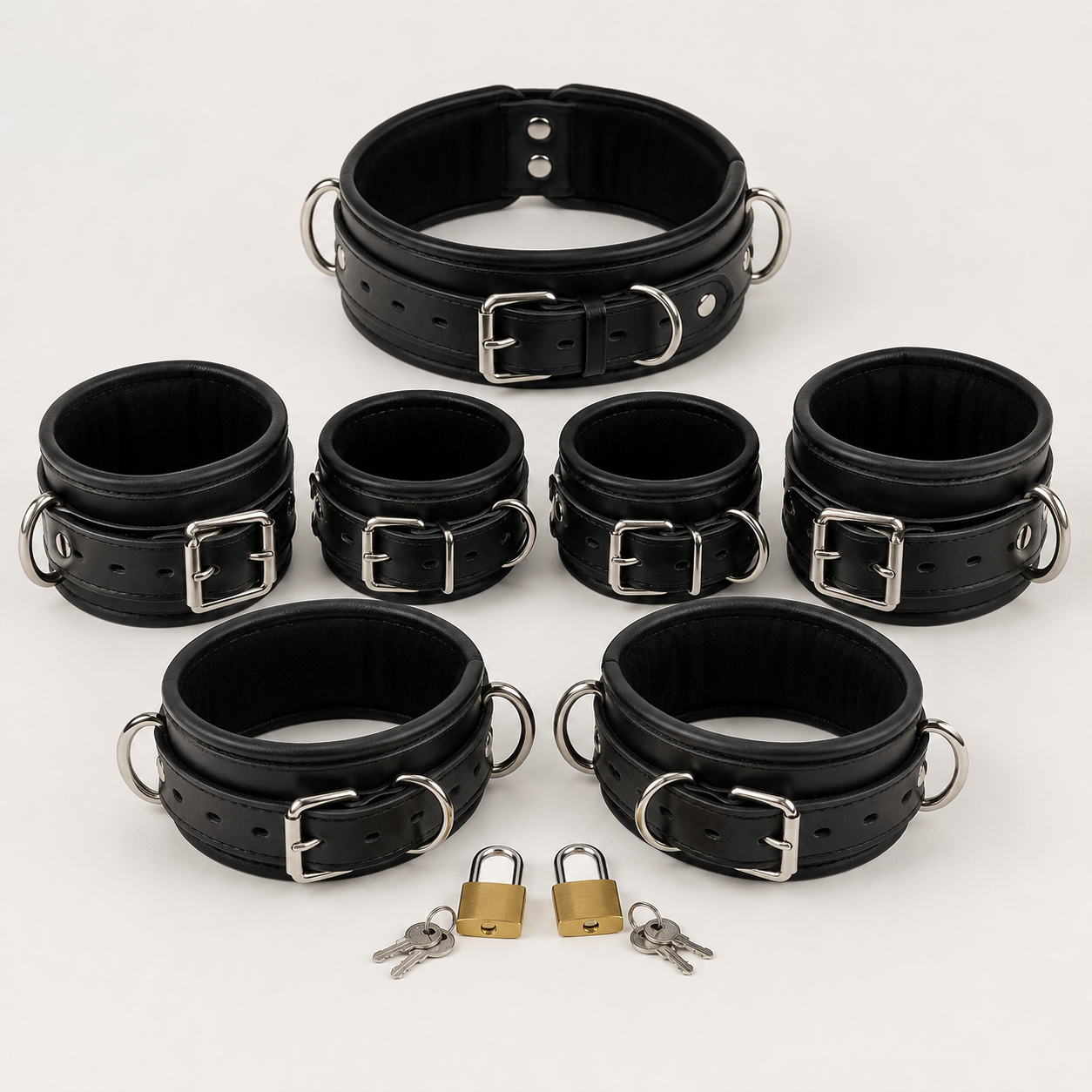 7 piece leather restraint set with padded collar, wrist cuffs, ankle cuffs and thigh cuffs arranged with padlocks and keys"