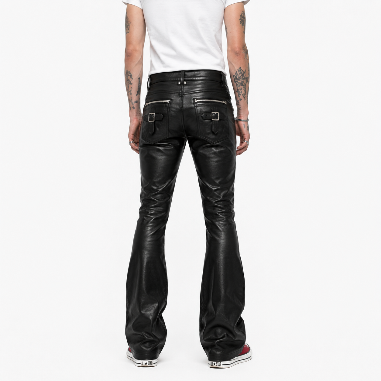 Back view of black leather pants showing buckle strap pocket detail and bootcut flare