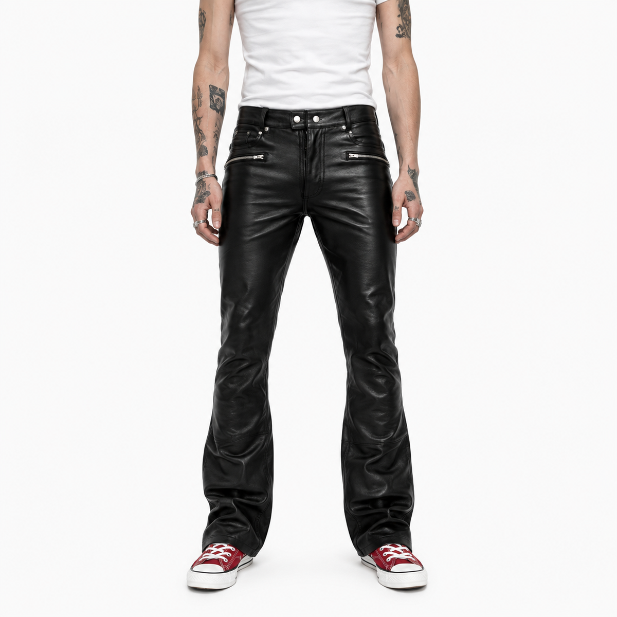 Men's black leather bootcut trousers with zip pockets, front view on model with white sneakers