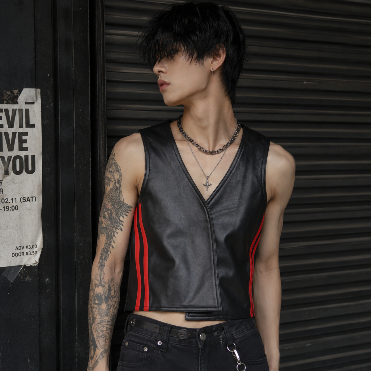 "Model wearing black leather cropped vest with red stripes in urban night streetwear look"