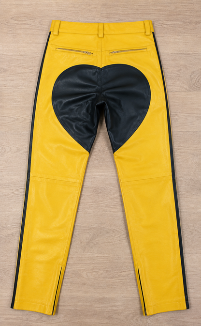 Yellow leather pants with black heart patch on back, flat lay